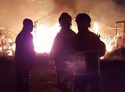 People look on as the fire rips through the boatyard. Picture: Dan Salter.