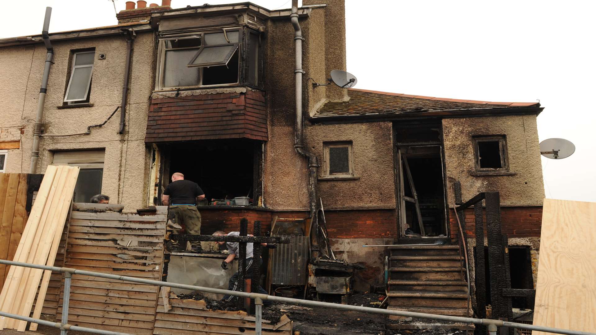 Men clearing debris after the property caught fire for the third time