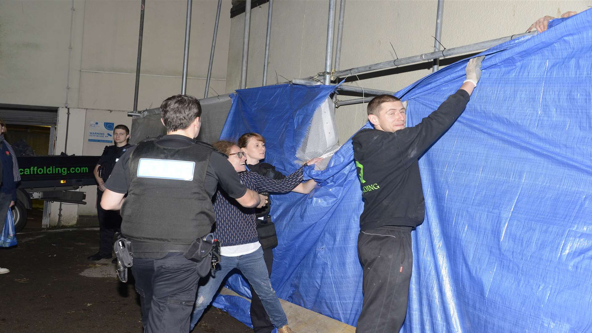 Protesters try to rip down tarpauline as police try to calm things. Picture: Paul Amos