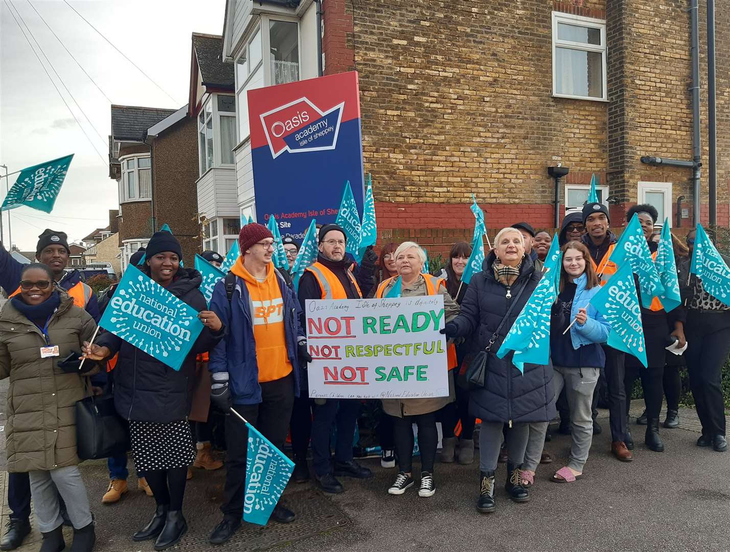 Teachers waving banners and placards on the picket line outside Oasis Academy