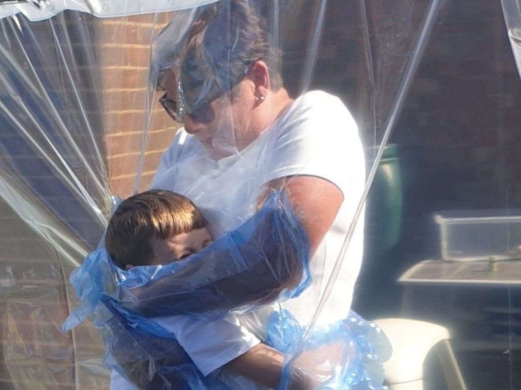 Nan Vicky hugging grandson Alex safely thanks to the cuddle curtain made by Vicky's son Thomas Ewing. Picture: SWNS