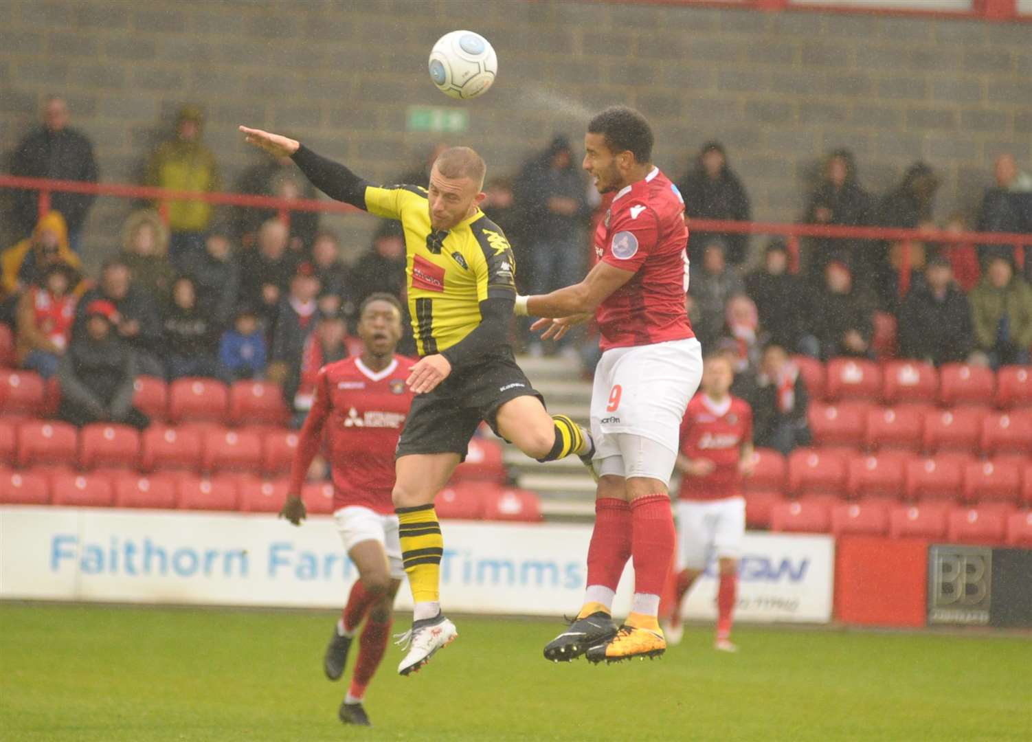 Chris Bush wins a header in the pouring rain at Stonebridge Road Picture: Steve Crispe