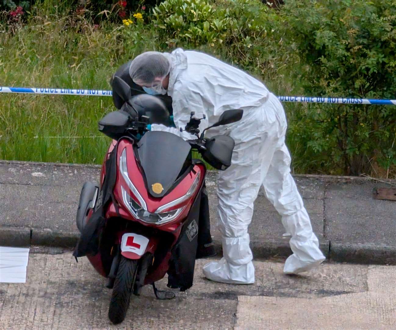 A forensic officer looking at a moped in Mooring Road, Rochester yesterday after a soldier was attacked in Sally Port Gardens, near Brompton Barracks