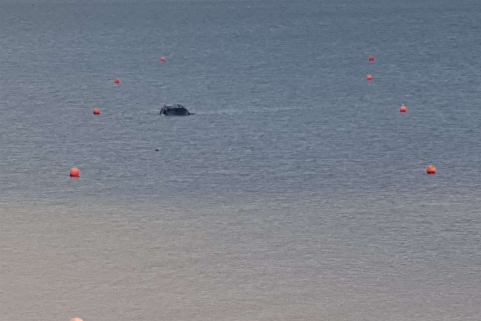 There is a danger that the car could be moved by the tide. Photo: Martin Nelson