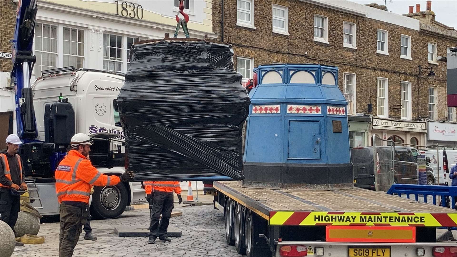 Day Four: The clock section, protected by black plastic, is craned onto a lorry at Sheerness ready to take it away for restoration