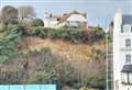 Trees tumble beneath clifftop house as road hit by second landslide