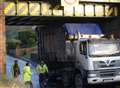 Duck! Truck gets stuck under bridge