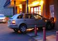 Woman hurt after car ploughs into shop