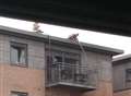 Fire crews scale the roof of flats to fight a blaze