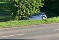 Car stuck on steep bank after hitting tree