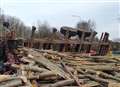 Logs fall off trailer after it overturns 