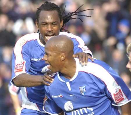 Leon Johnson wheels away after putting Gills ahead against MK Dons and is congratulated by Brent Sancho. Picture: GRANT FALVEY