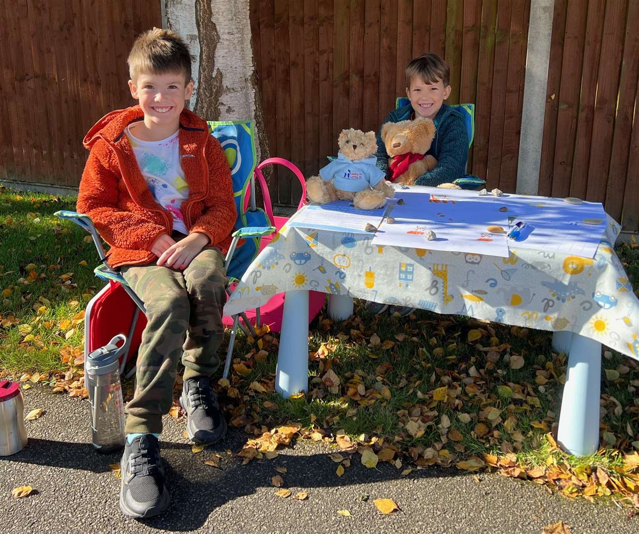 Oliver (left) sat outside his home in Harrietsham to sell his drawings. Picture: HOLG