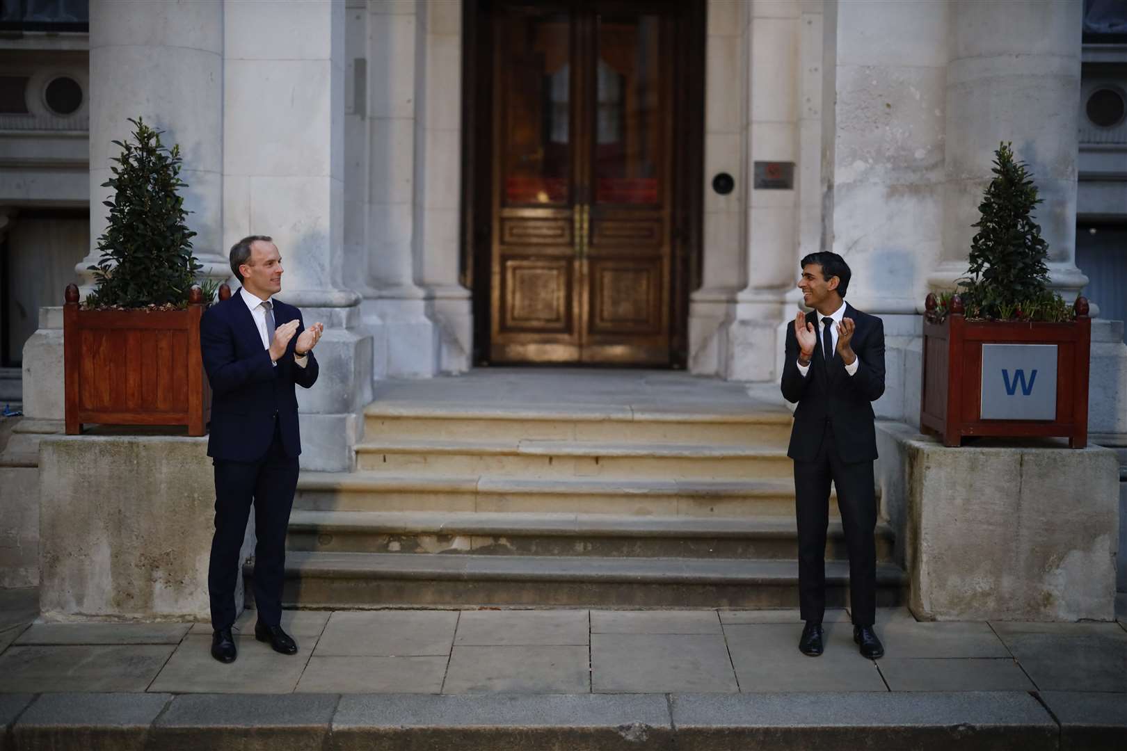 Foreign Secretary Dominic Raab and Chancellor Rishi Sunak clapping outside the Foreign and Commonwealth Office (Tolga Akmen/PA)