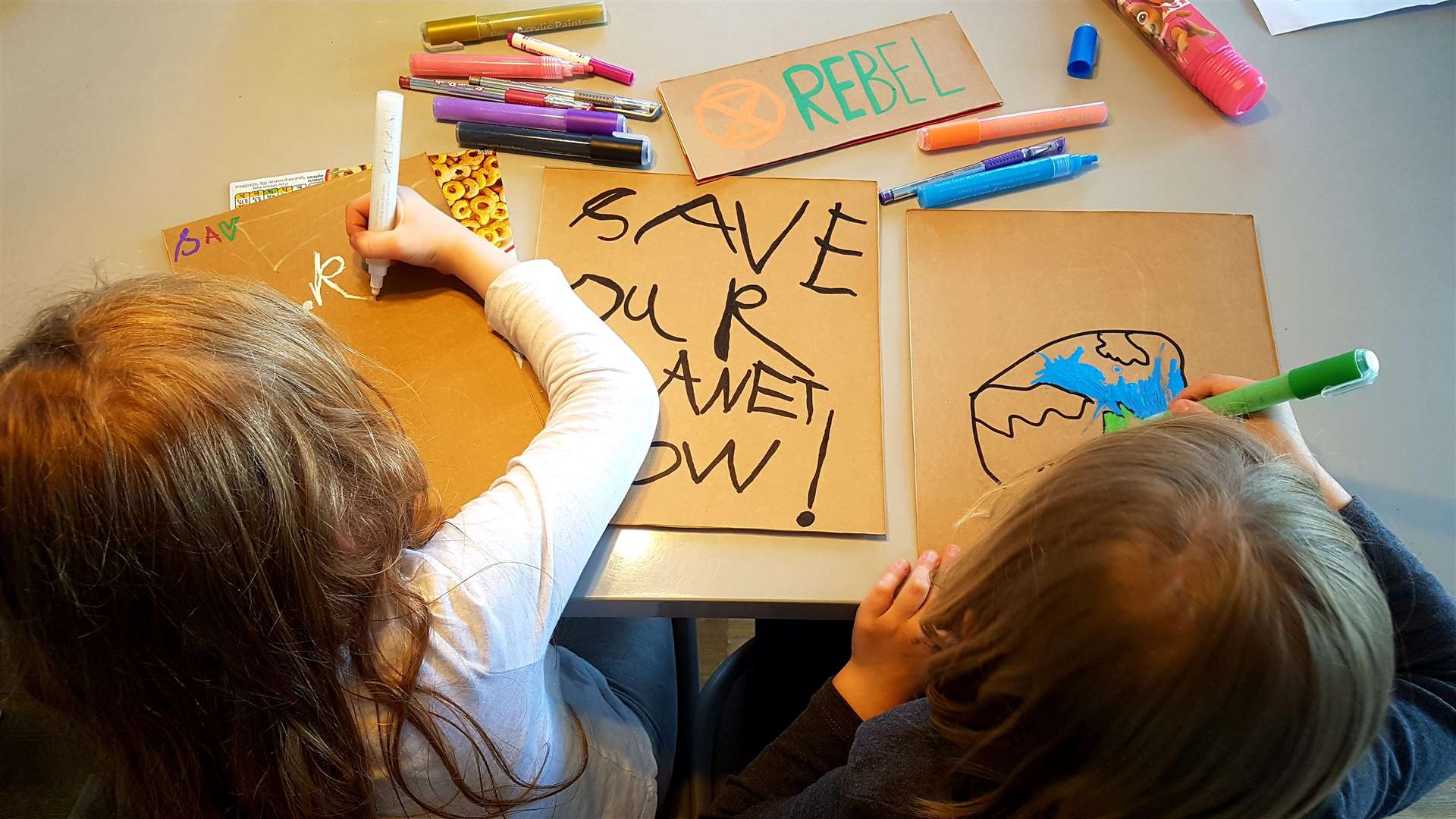 Amelia and Leo prepare their signs for the demonstration, using recycled cereal boxes