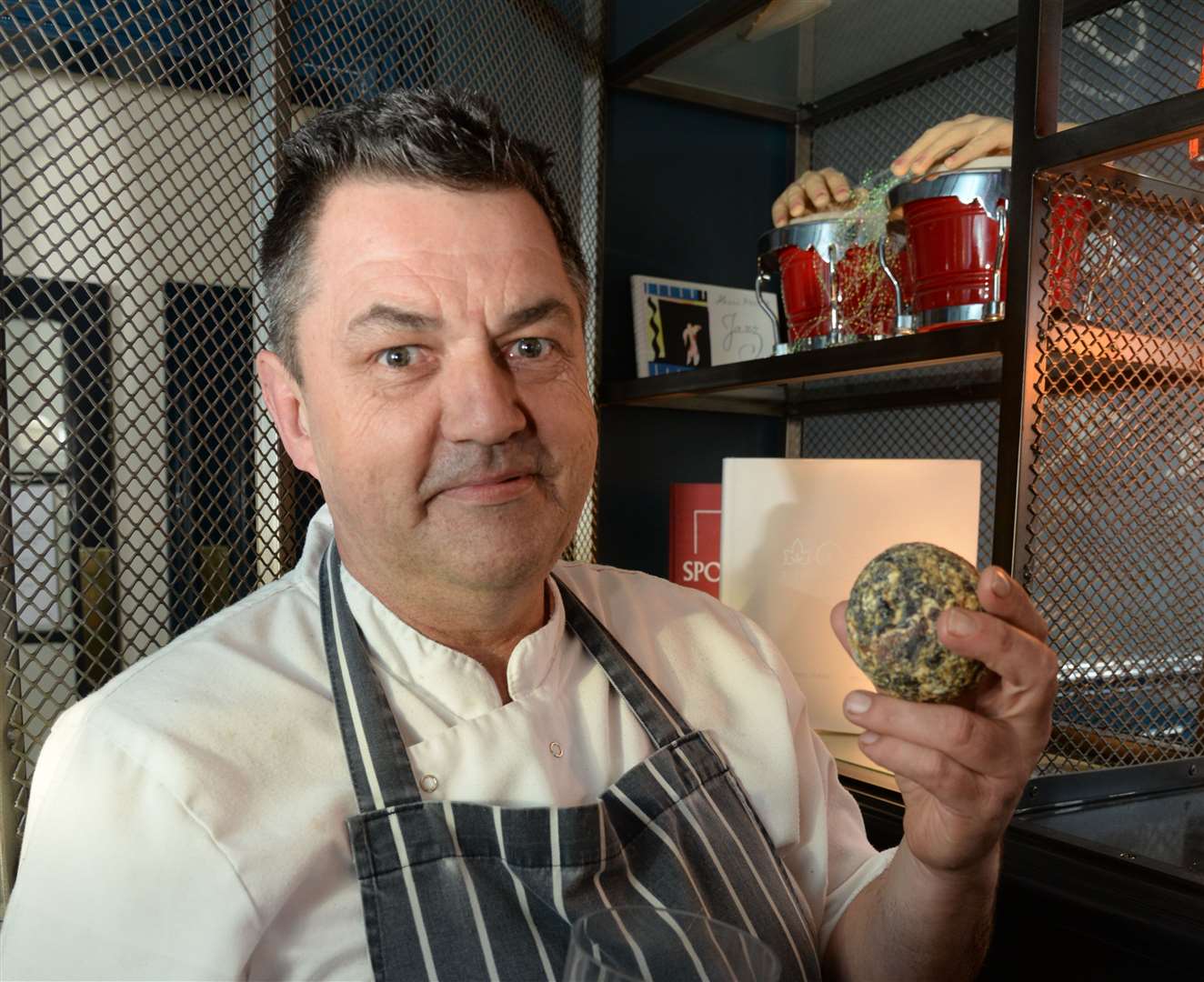 Joe Mullane holds a ball of whale vomit at the Four Fathoms, which was found in Italy