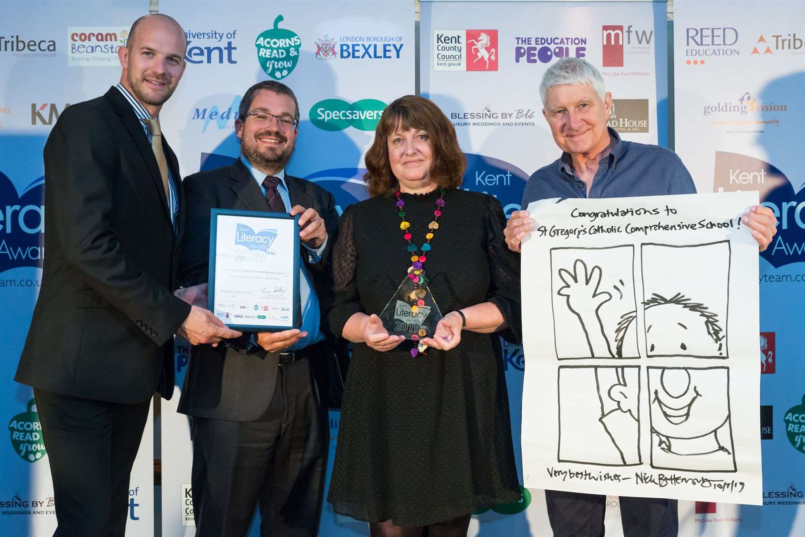 Kim Stanley of St Gregory’s Catholic School receives award from Mike Wood of Hempstead House and Max Howells of University of Kent, plus signed cartoon from Nick Butterworth.