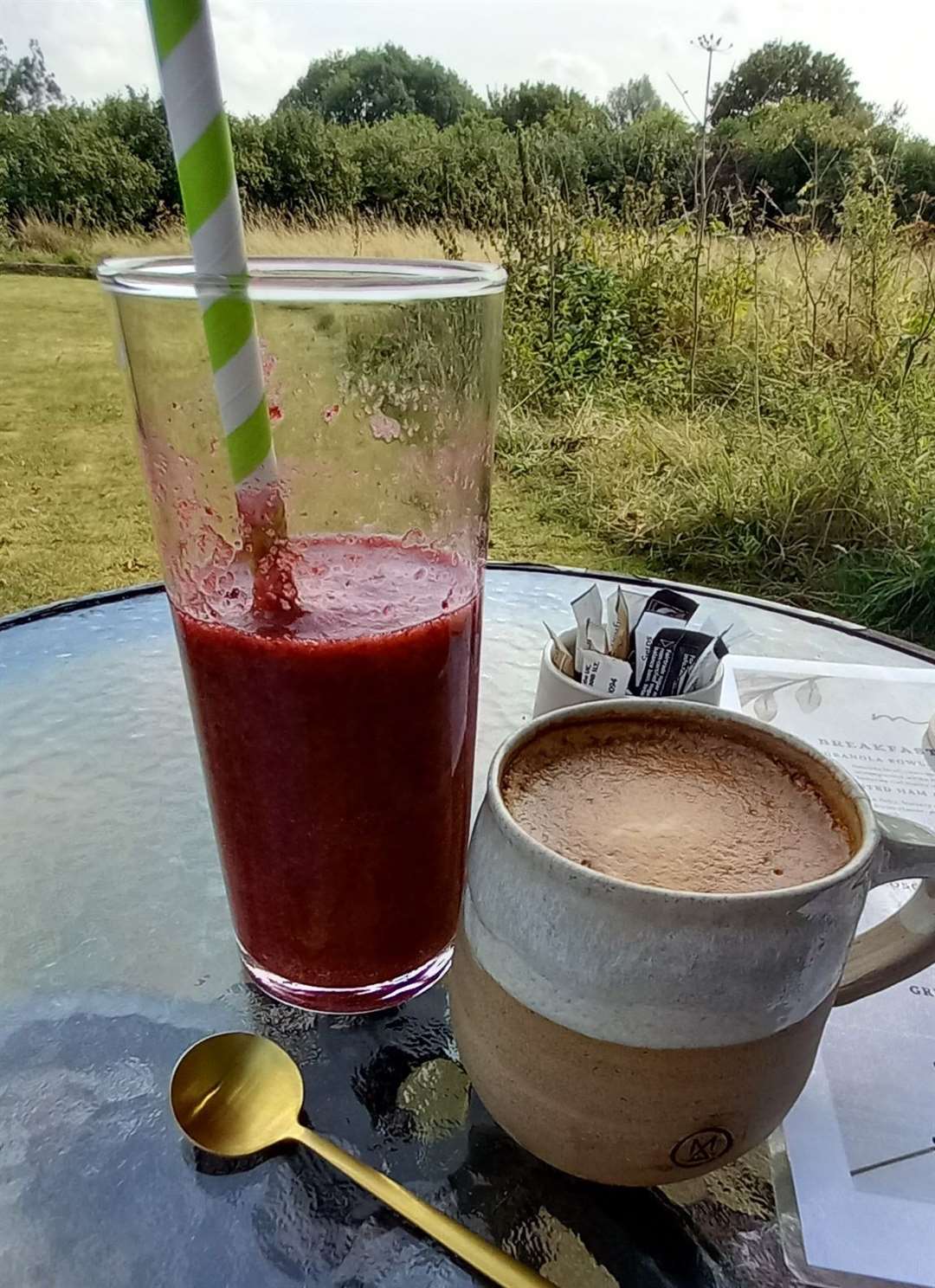 A berry smoothie and a flat white in a mug made by Michelle