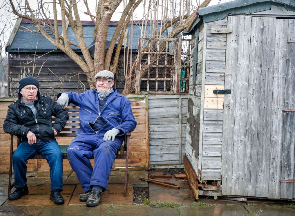 Warden Garry Jacobs, left, and Jim Burlton sit where the shed used to stand