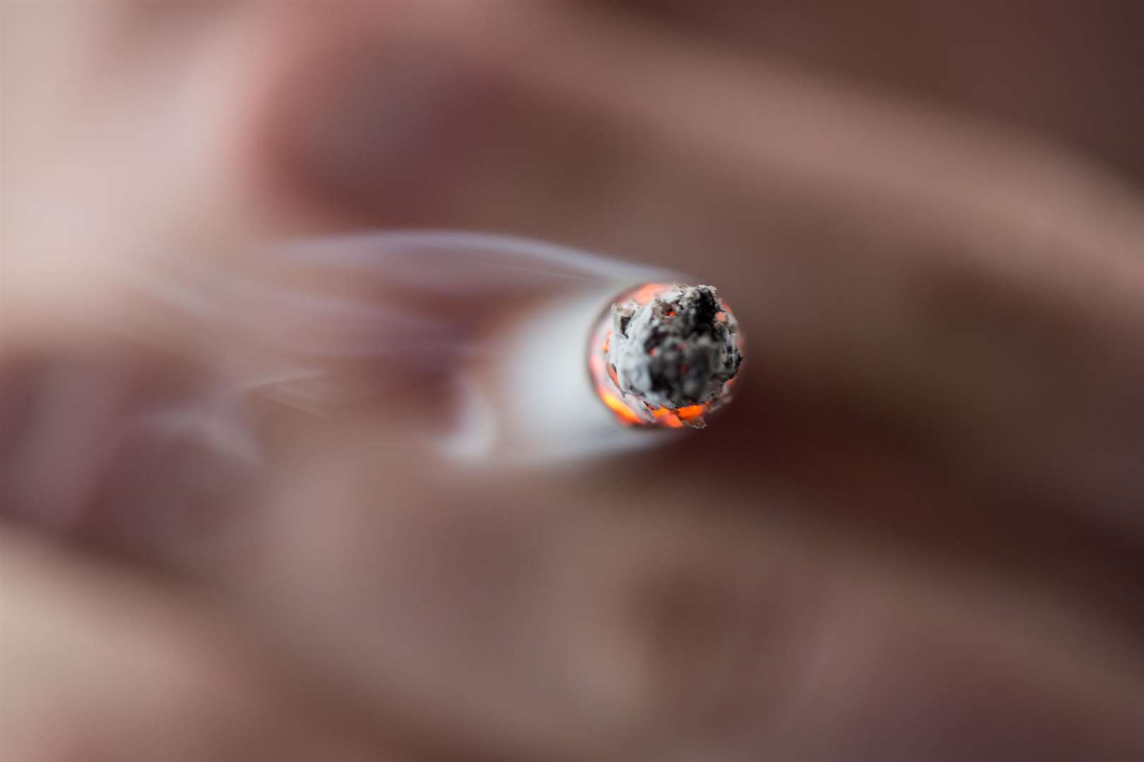 Someone smoking a cigarette. Stock image.