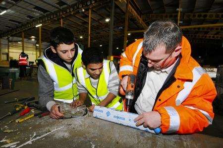 Terry Fox, director of Think3E, showing apprentices Philip Illman, 16, and Lewis Bovell, 19, what they will be doing in the workshop.