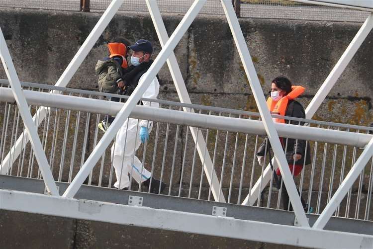 A group of people, including a child, thought to be seeking asylum in the UK, being brought into Dover in September. Picture: Gareth Fuller/PA