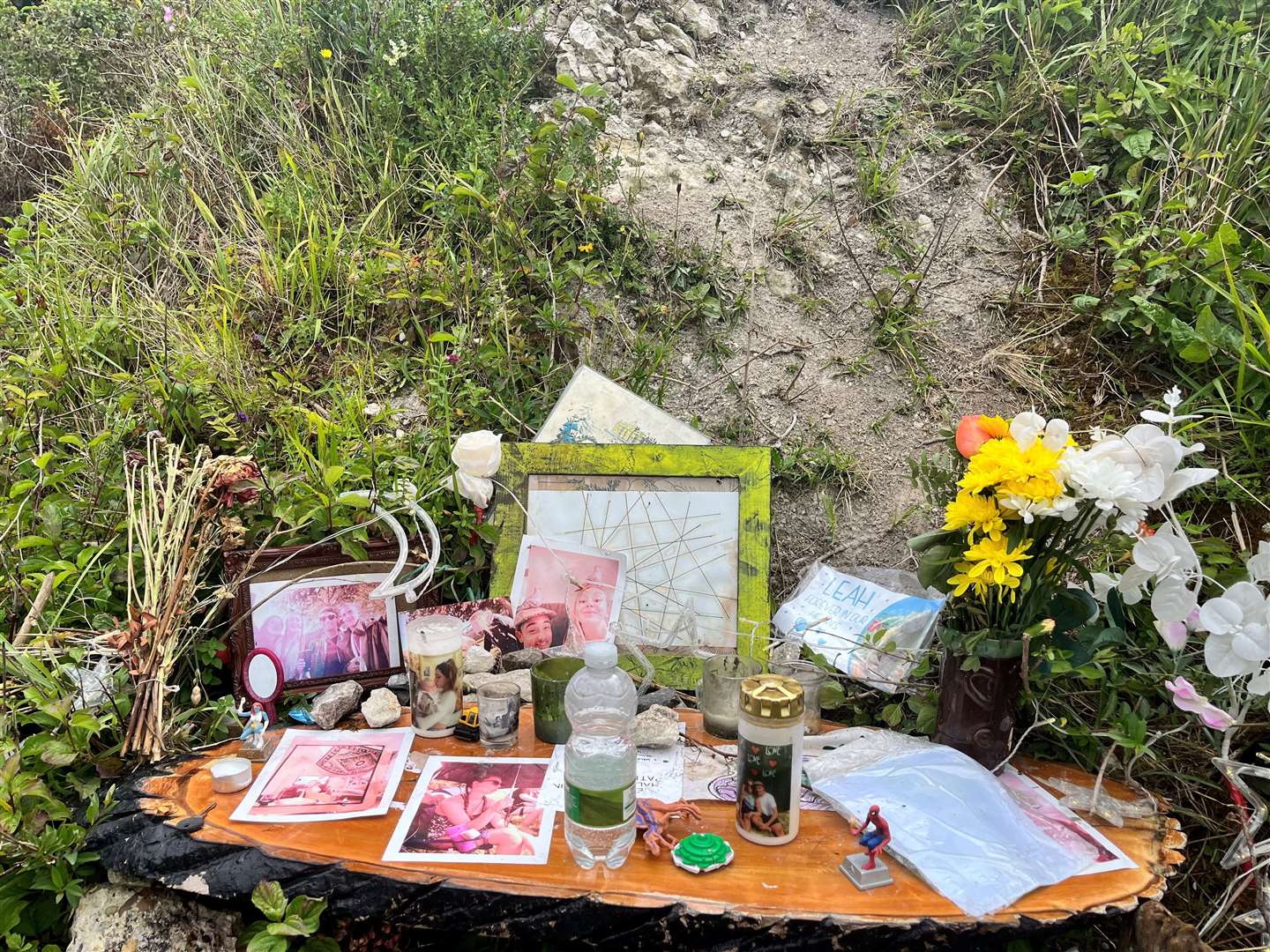 Pictures, messages and flowers in memory of Leah remain at the spot where she was found in The Warren