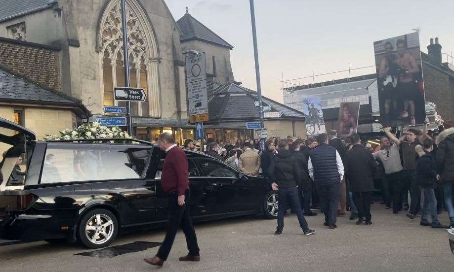 Pictures are held aloft of the victims of a crash which claimed four lives on October 10, near Headcorn