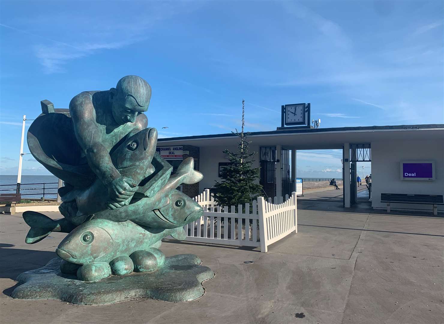 The Deal tree is behind a large statue at the entrance to the pier