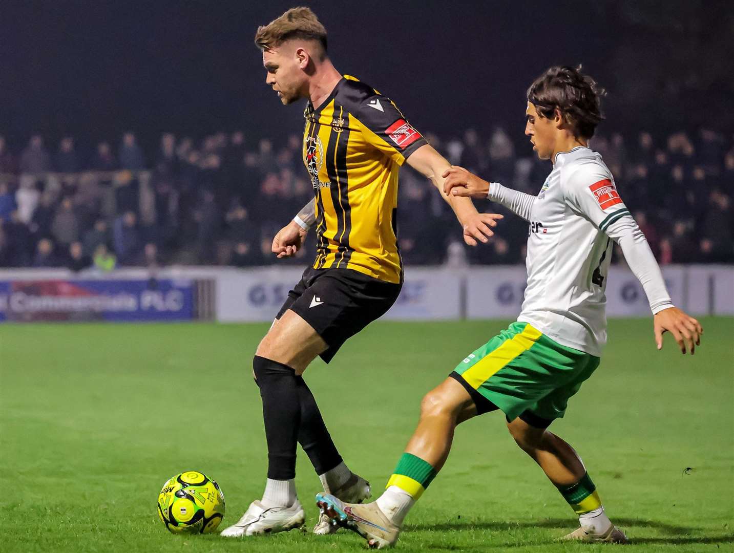 Folkestone midfielder Jack Jebb does battle with Dover’s George Wilkinson. Picture: Helen Cooper