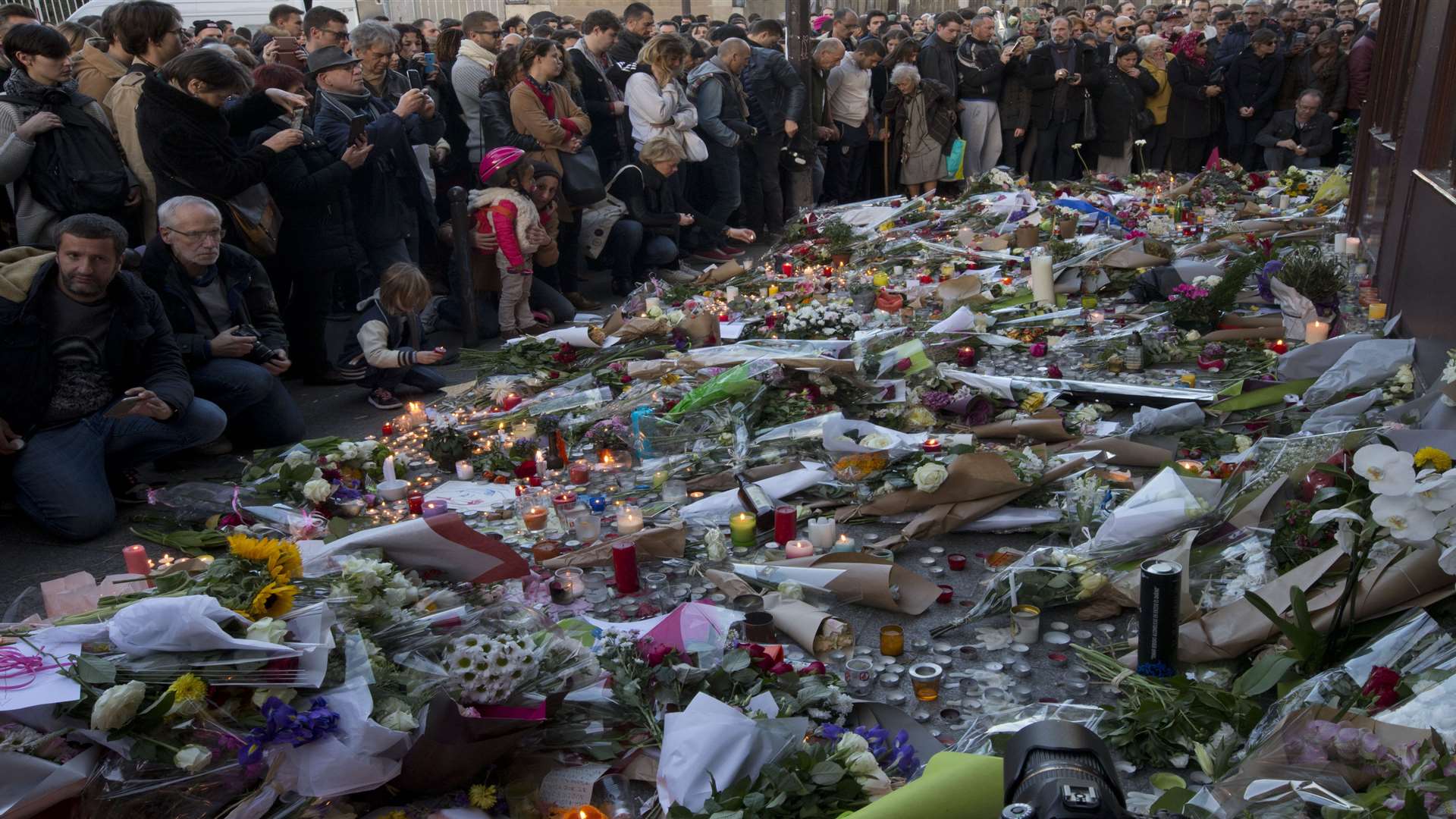 People pay their respect to the victims at the site of the attacks on restaurant Le Petit Cambodge and the Carillon Hotel. Picture: AP Photo/Peter Dejong