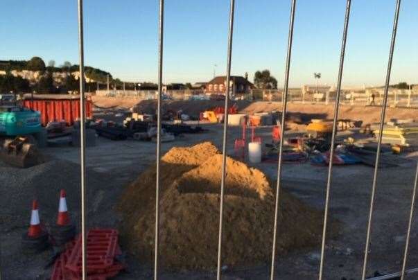 A view of the Riverside Tavern in the distance through the railings surrounding the building site