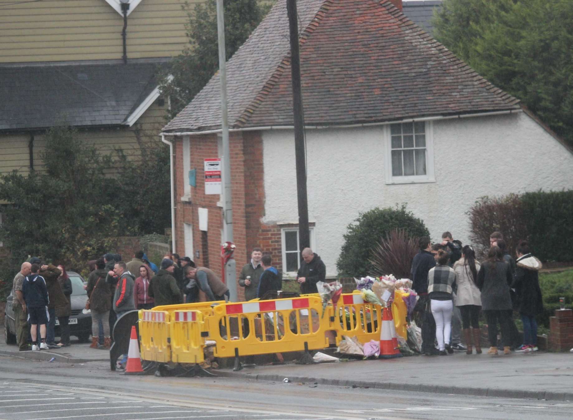 Mourners gather at the scene the day after the crash