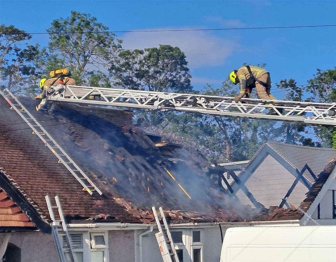 Firefighters used an extended ladder to reach the burning roof