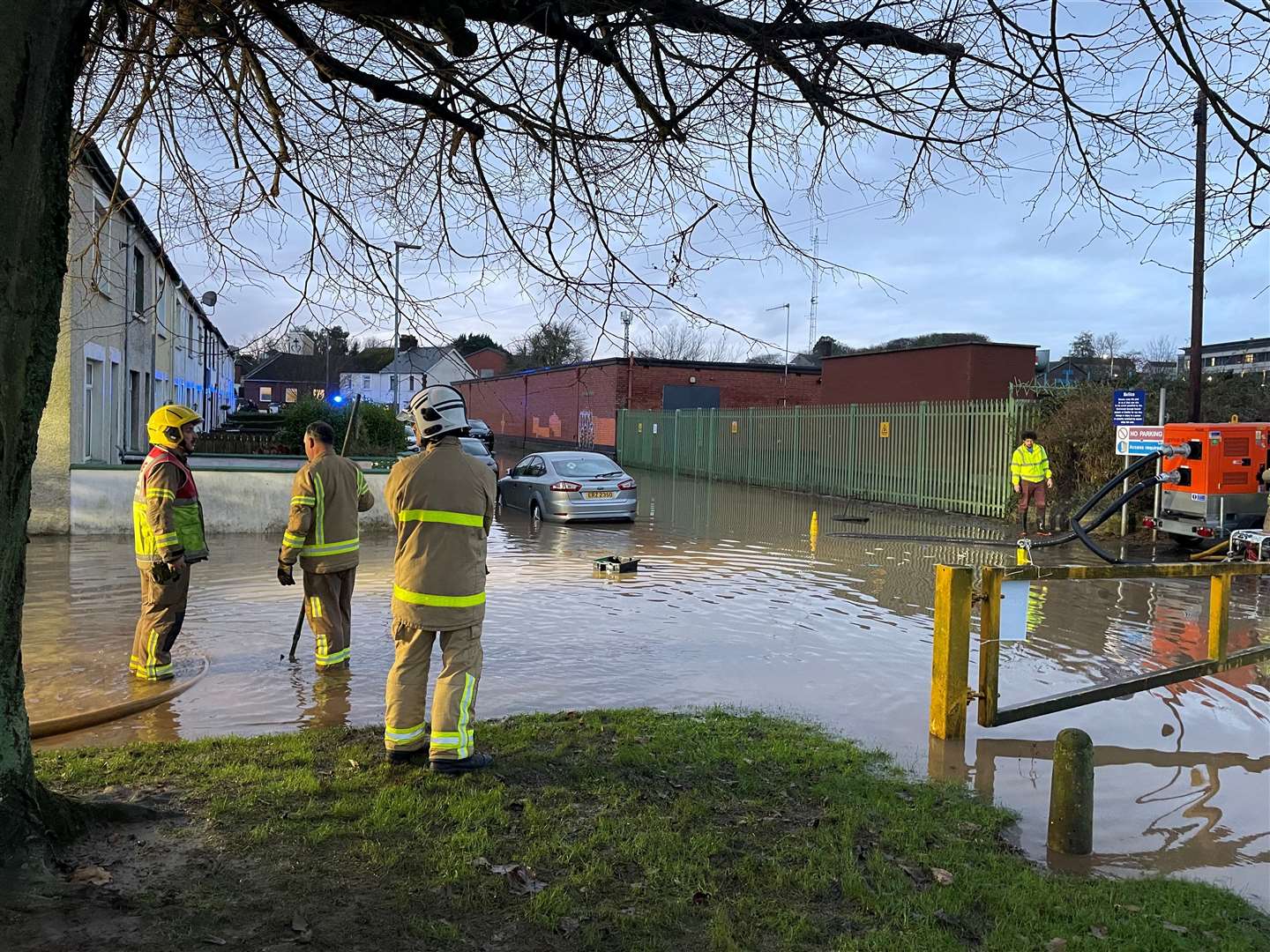 Firefighters work to pump water away from flooded residential streets near Moat Park in Dundonald, on the outskirts of Belfast (PA)