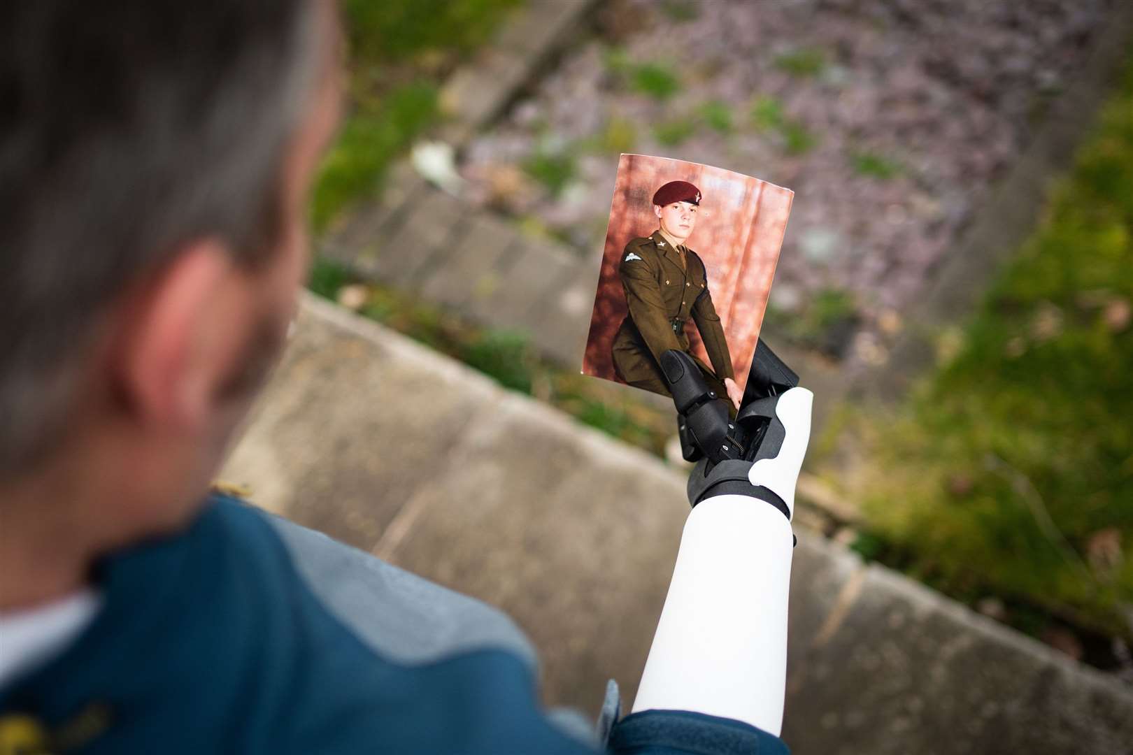 Darren's bionic arm holding a photo of himself from his days in the army. Picture: SWNS