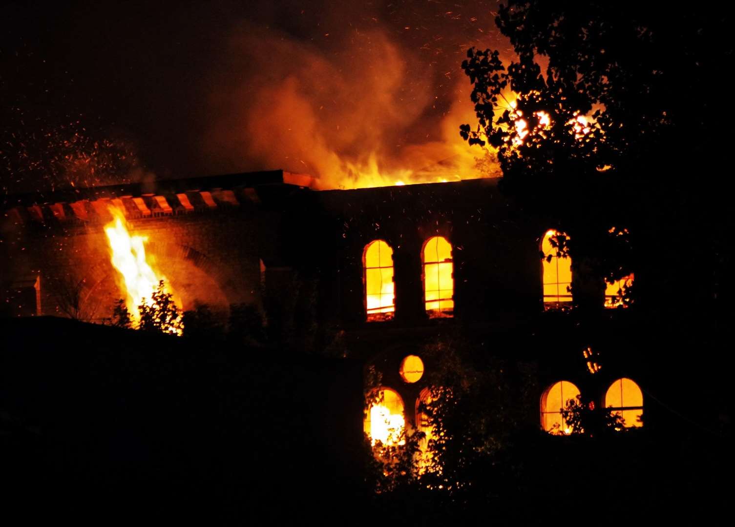 Flames coming out of the windows and roof of the blazing water tower in Trinity Road, Sheerness. Picture: Phil Crowder