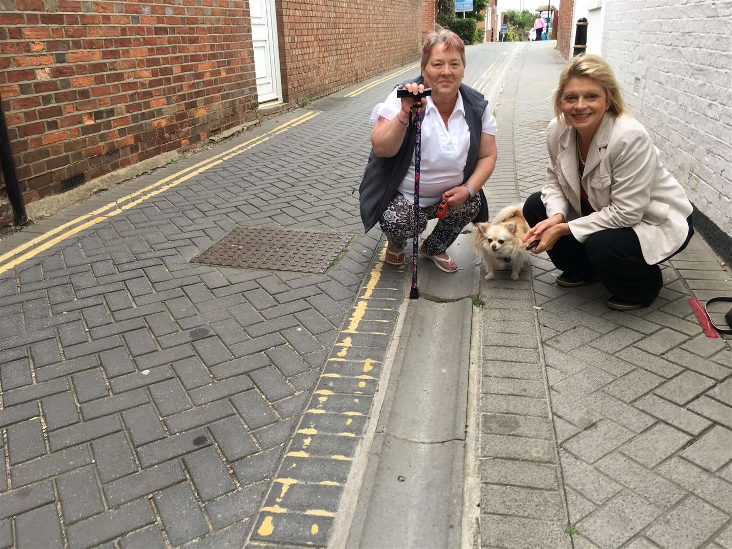 Cllrs Sue Ferguson and Nikki Gooch examining the damaged pavement