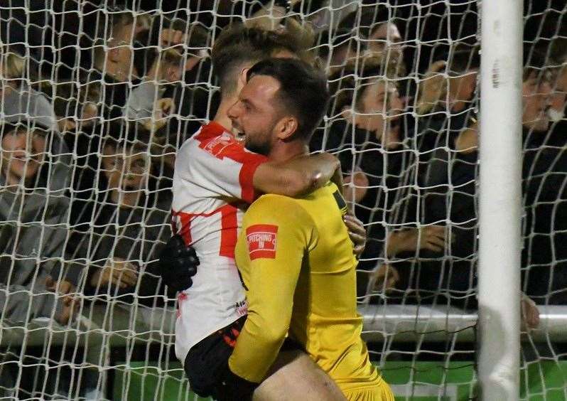 Sheppey goalkeeper Aiden Prall picks up penalty shoot-out winner Jacob Lambert as they beat Billericay 5-4 on penalties on Tuesday night after a 1-1 draw to book their place in the First-Round of the FA Cup. Picture: Marc Richards