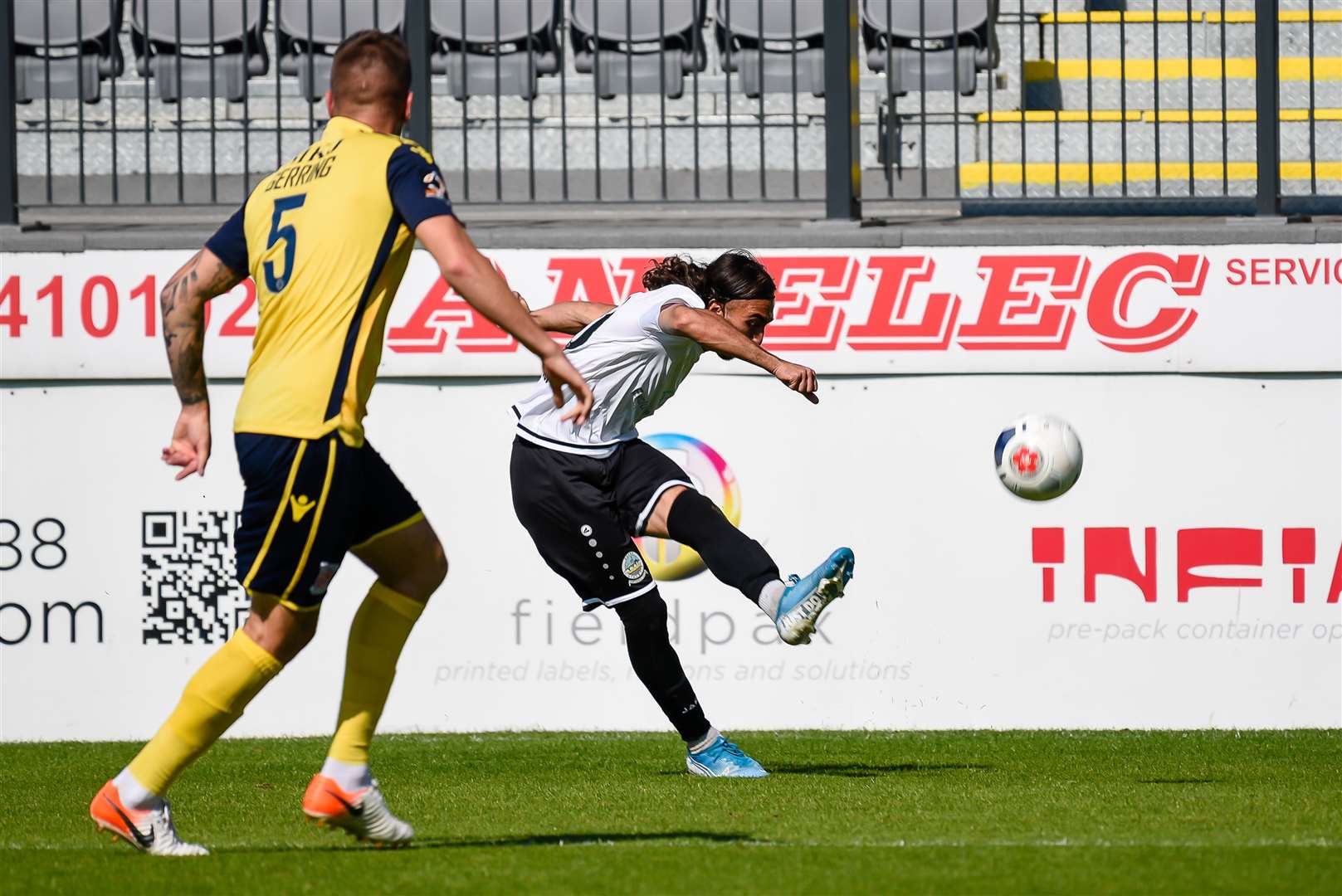 Dover's Nassim L'Ghoul gets a cross away after beating Woking's Ben Gerring. Picture: Alan Langley