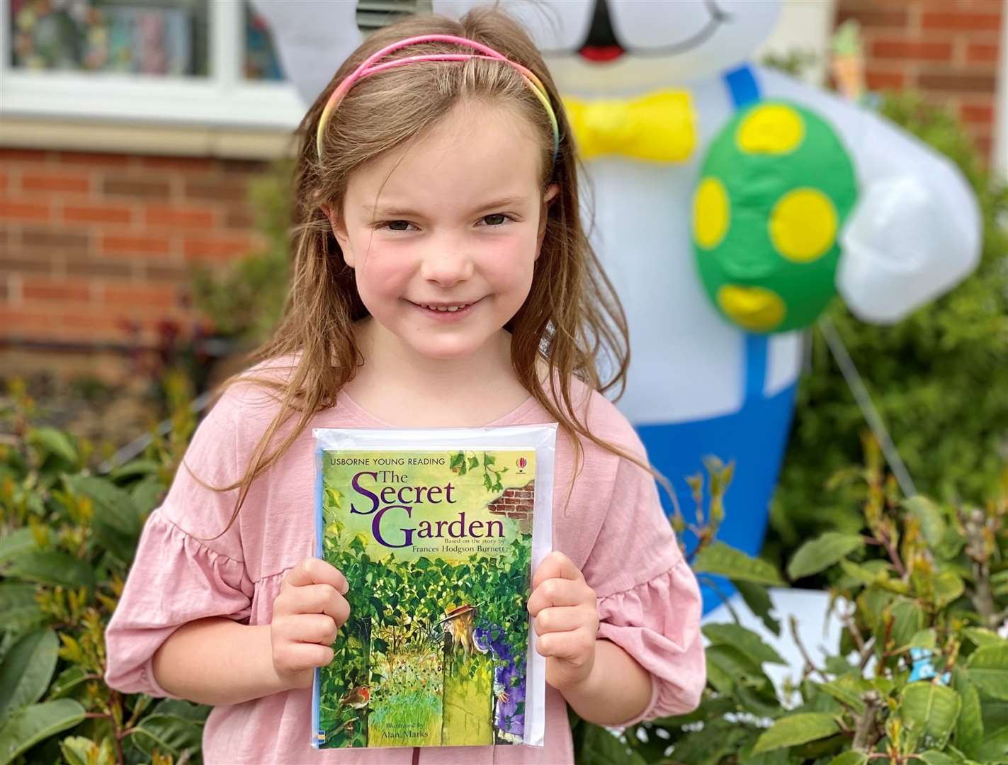 Emelia, aged six, poses with book The Secret Garden