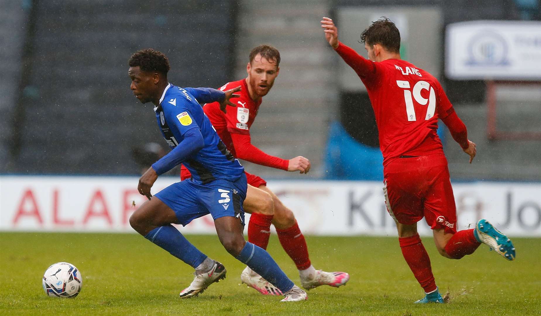 Gillingham defender David Tutonda gets away from two Wigan players. Picture: Andy Jones (51835488)