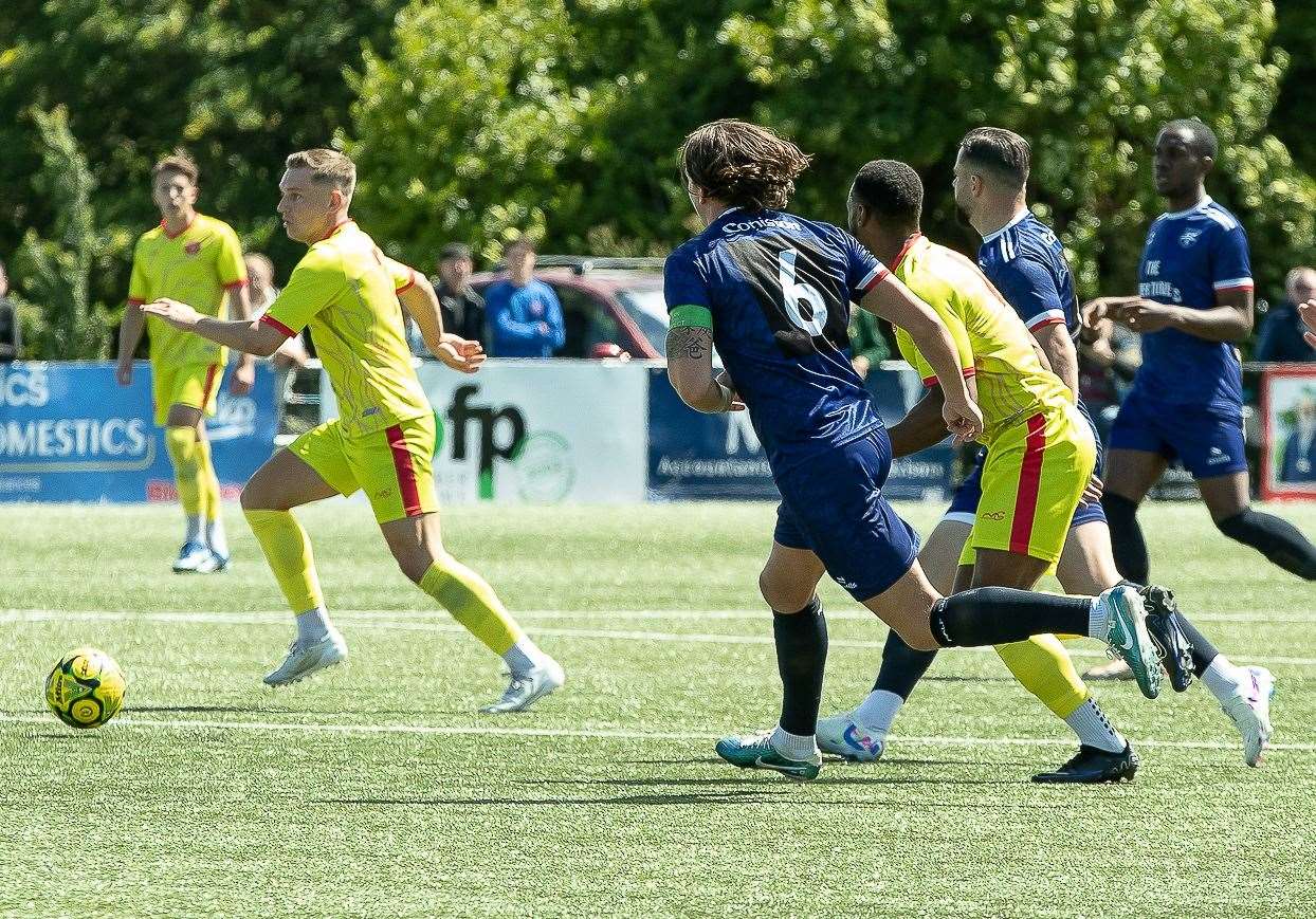 Whitstable midfielder Josh Oliver moves forward and away from new Margate captain Harry Hudson (No.6) during Gate’s campaign-opening 3-0 weekend win at Hartsdown Park. Picture: Les Biggs