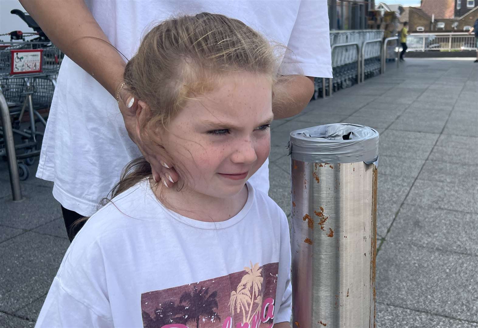 Katie O'Shea's daughter, Jamie Beecham, by the pole that shredded her mum's top outside Aldi in Sittingbourne