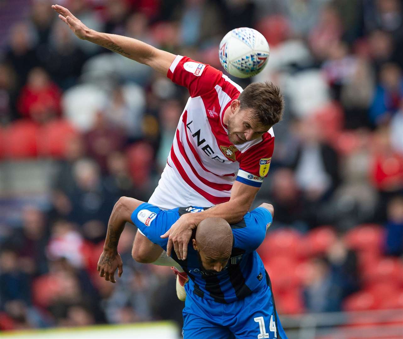 Andy Butler climbs all over Gillingham's Josh Parker. Picture: Ady Kerry