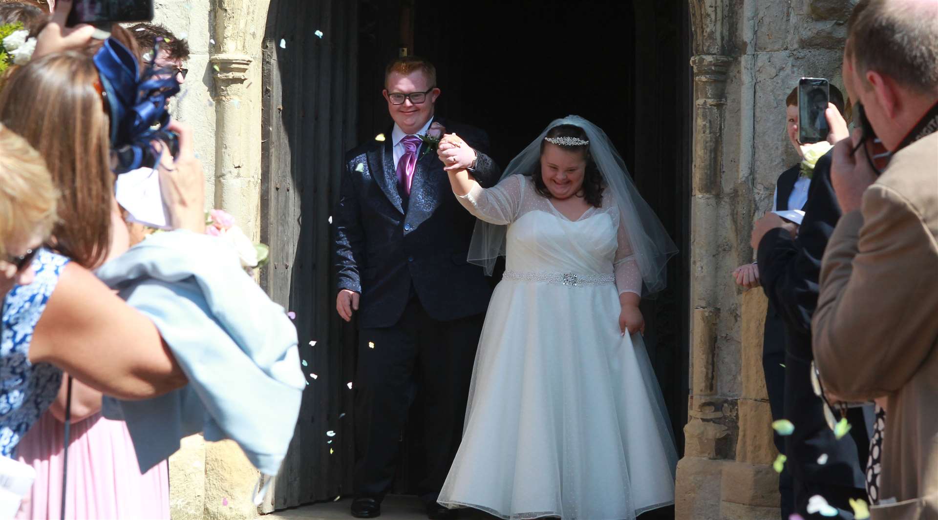 Kieran and Emma Duffy emerge from All Saints Church, for the traditional throwing of confetti in the summer Picture: John Westhrop