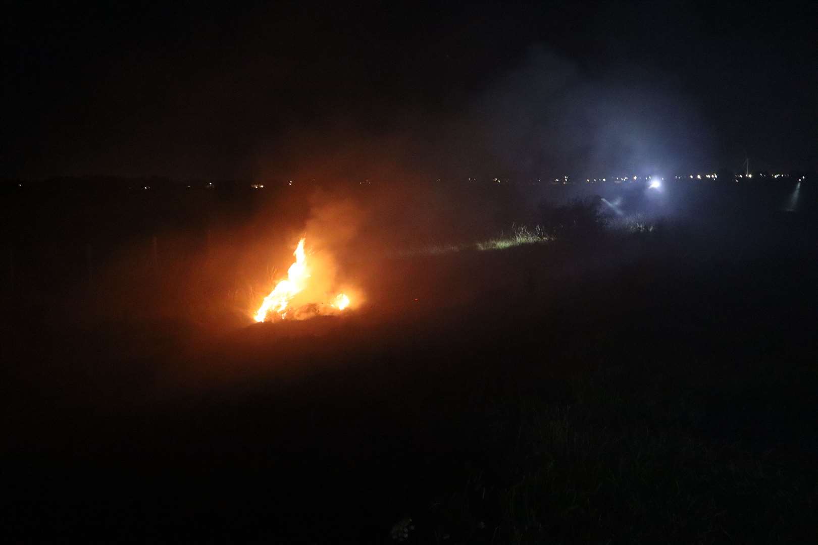 Firefighters tackle burning grass following a model aeroplane display at Barton's Point Coastal Park, Sheerness. Picture: John Nurden