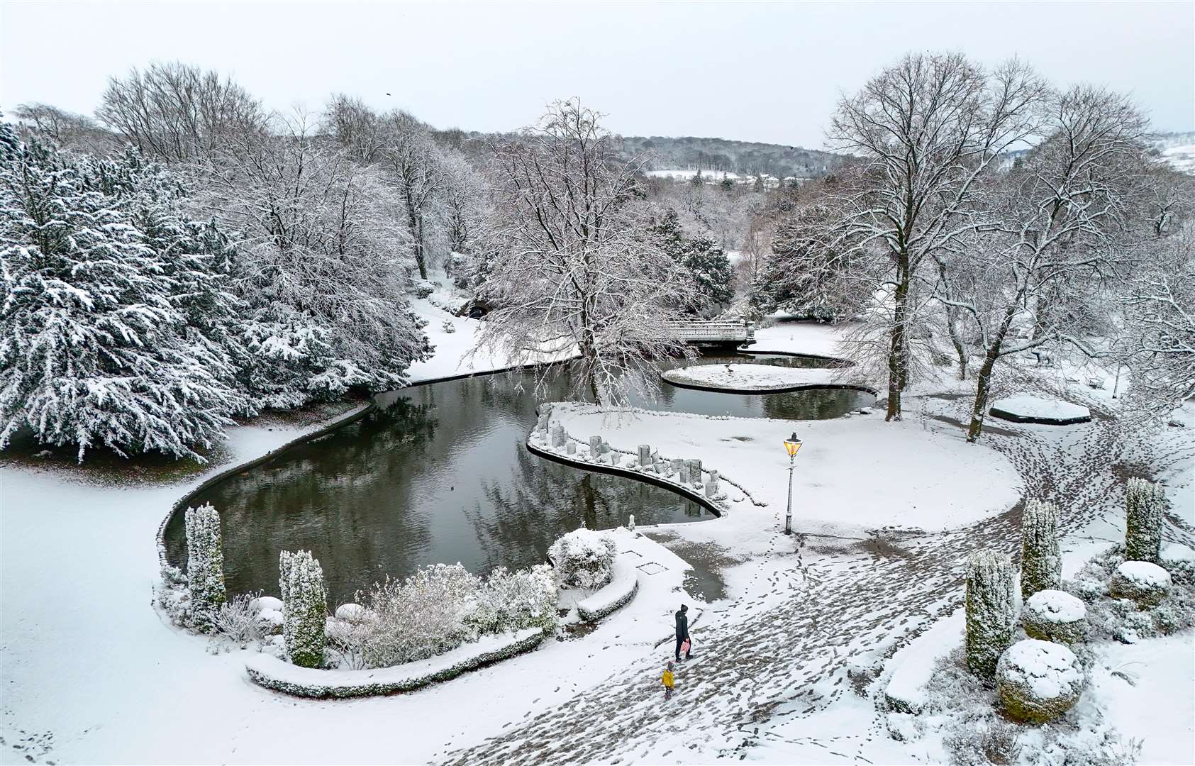 People walk through a park after overnight snowfall in Buxton (Peter Byrne/PA)