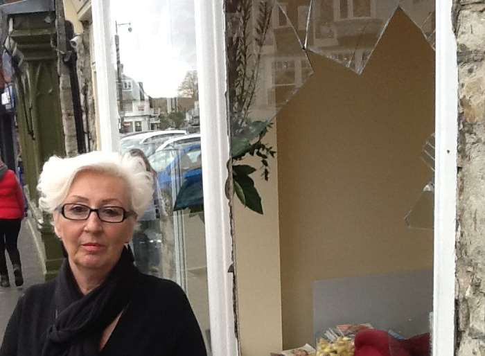 Owner Annie Lucas stands next to the damaged window at her salon in West Malling