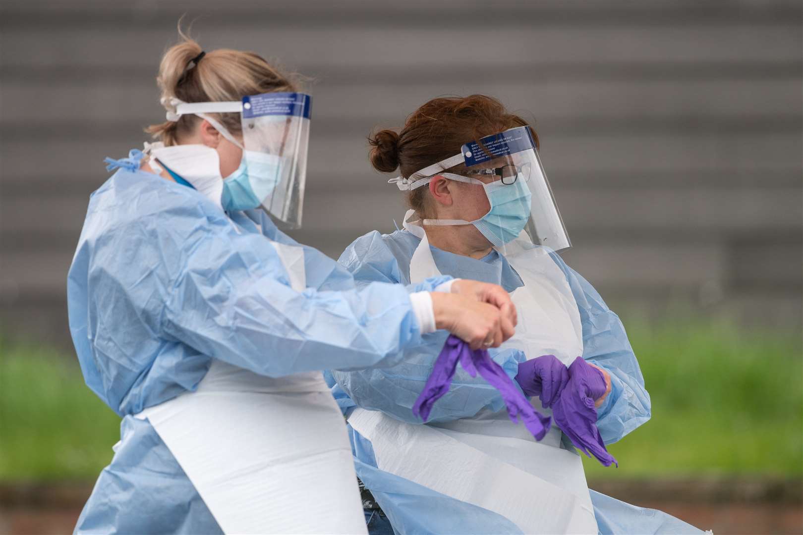 NHS staff put on personal protective equipment before carrying out coronavirus tests at a facility in Bracebridge Heath, Lincoln (Joe Giddens/PA)